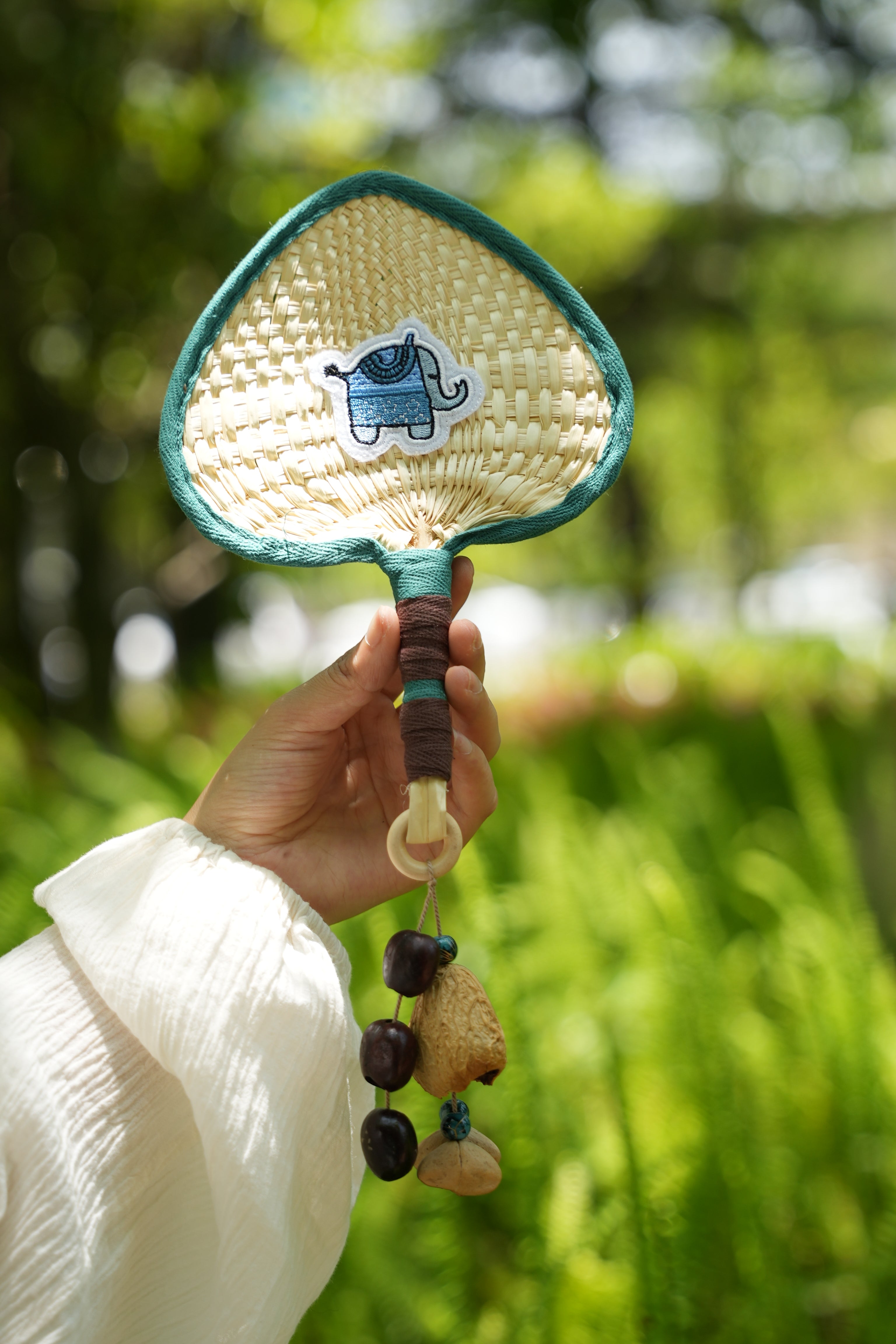 "The Lucky Breeze" - Hand-Woven Heart Palm Fan with Blue Elephant & Seed Charm